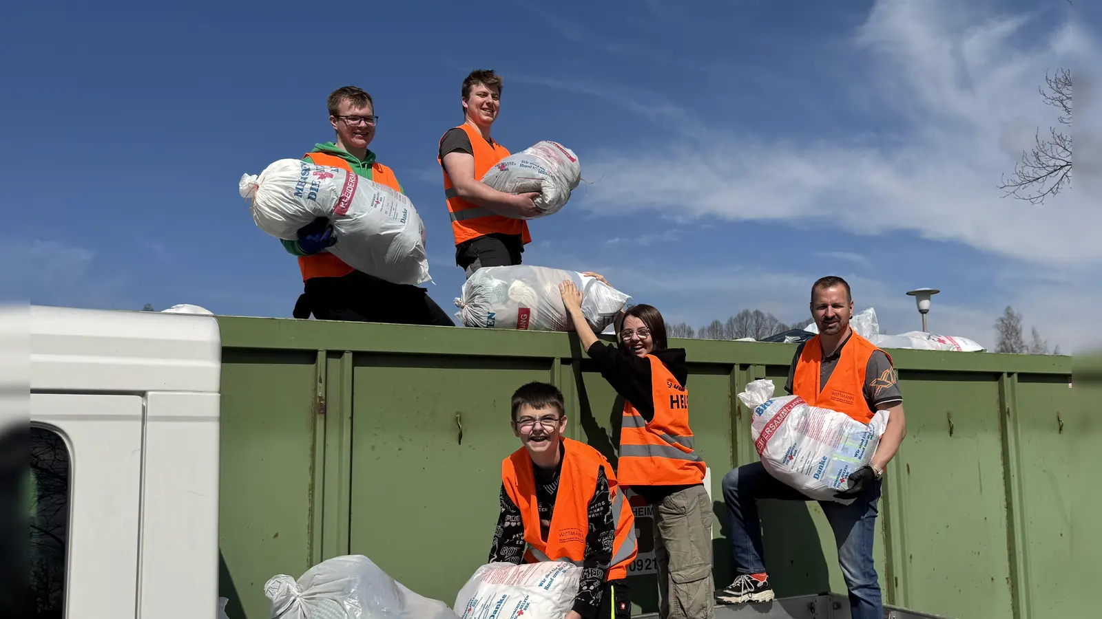 Fleißig wurden wieder die Kleiderspenden von den Rotkreuzlern am Kreinzel von den Sammlungsfahrzeugen auf den Container der Spedition verladen, bis dieser am Ende der Altkleidersammlung der Bereitschaft Erbendorf im BRK randvoll war. (Bild: Sven Lehner)