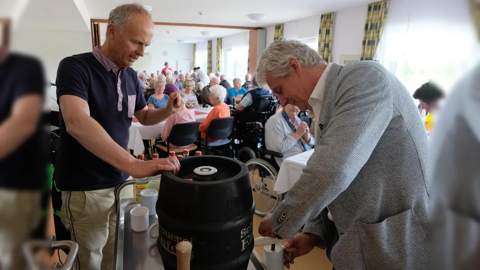 Maifeier im Seniorenwohnheim „Am Reiserwinkel“. Bürgermeister Robert Lindner rechts) zapfte mit Hilfe von Heimleiter Carsten Fischer (links) das frische Fass Bier an.  (Bild: Fred Lehner)