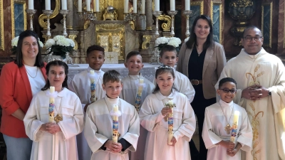 Sieben Kinder aus Schlicht empfingen in der Pfarrkirche St. Georg in Schlicht die Erstkommunion. Zusammen mit Pfarrvikar Pater Jimmy Joseph und den Tischmüttern Anja Wendl (li) und Sabrina Lindner stellten sie sich nach dem Gottesdienst vor dem Hochaltar zum Erinnerungsfoto auf. (Bild: Christian Trummer)