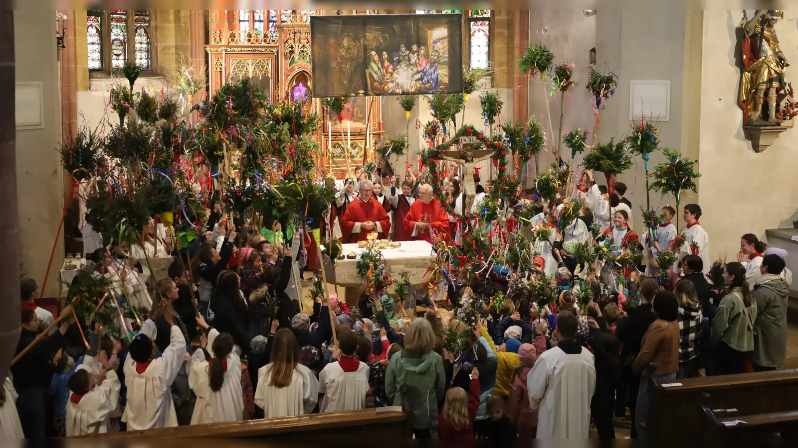 Kindergartenkinder, Erstkommunionkinder und Firmlinge füllten mit ihren bunten Palmbuschen den gesamten Altarraum und winkten zum Friedensgruß allen Mitfeiernden im Kirchenschiff. (Bild: Sepp Ferstl )