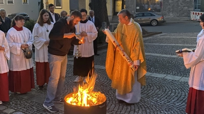 Josef Pflaum jun. entzündet die Osterkerze, die Pfarrer Norbert Götz hält. (Bild: Franz Völkl)