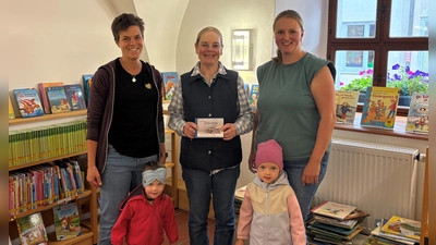 Die Leiterin der Krabbelgruppe Melanie Luber und Karina Lederer überreichen die Spende an die Büchereileiterin Maria Klobes-Martin. (Bild: Leonie Tafelmeier)