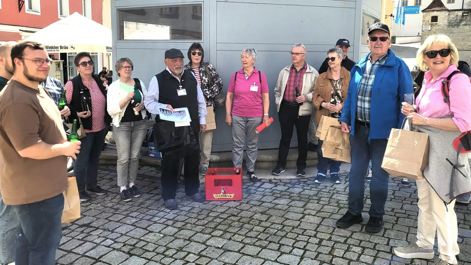 Ein Prosit auf Tradition und Gemeinschaft: Teilnehmer der Bier-Tour stoßen am historischen Löwenbrunnen auf die reiche Braukultur Sulzbach‑Rosenbergs an. (Bild: Walter Heldrich)