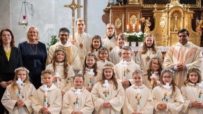 Die Erstkommunionkinder mit den Tischmüttern Andrea Monath und Silke Bächer, Pfarrer Joseph (hinten von links), den Ministranten sowie Pater Martin (hinten, rechts).  (Bild: Alexander Schoen/exb)