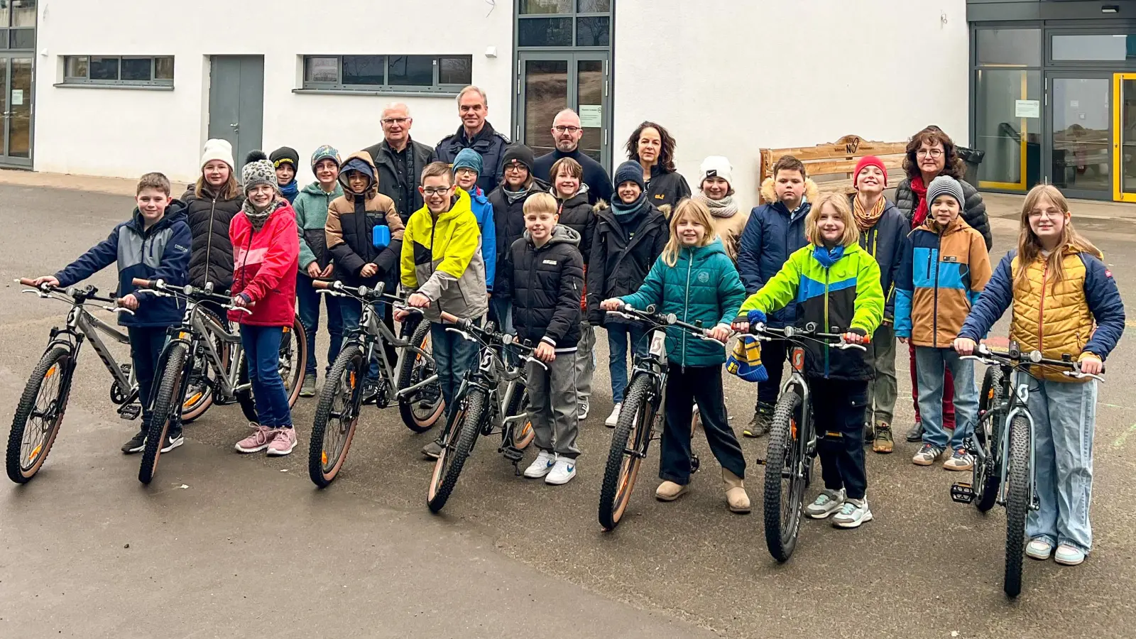 Spendenübergabe an der Grundschule Neunburg: Lions-Mitglied Michael Steidl, Polizeioberkommissar Markus Schlegel von der Polizei Neunburg, Lions-Präsident Thorsten Matheja, Rektorin Sabine Bauer und die Verkehrs- und Sicherheitsbeauftragte der Grundschule, Heike Hanisch (hinten von links) freuten sich mit den Schülern, die die neuen Räder gleich ausprobierten. (Bild: Marcus Paulus)
