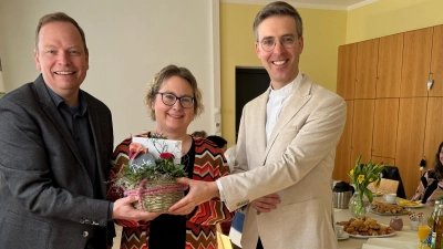 <br>Kirchenpfleger Michael Kippes (links) und Stadtpfarrer Thomas Kopp verabschieden Pfarrsekretärin Sabine Zenger. Ganz rechts sitzend Stadtpfarrer a. D. Josef Häring.  (Bild: Martin Staffe)