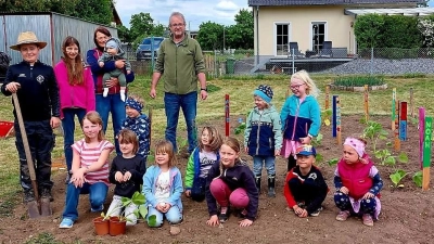 Besonders stolz waren die Kürbis-Pflanzer auf ihre tollen Namensschilder. Praktische Hilfe beim Einpflanzen leisteten auch die beiden Vorsitzenden Jürgen Hofmann und Ilse Dehling.  (Bild: Claudia Kausler )