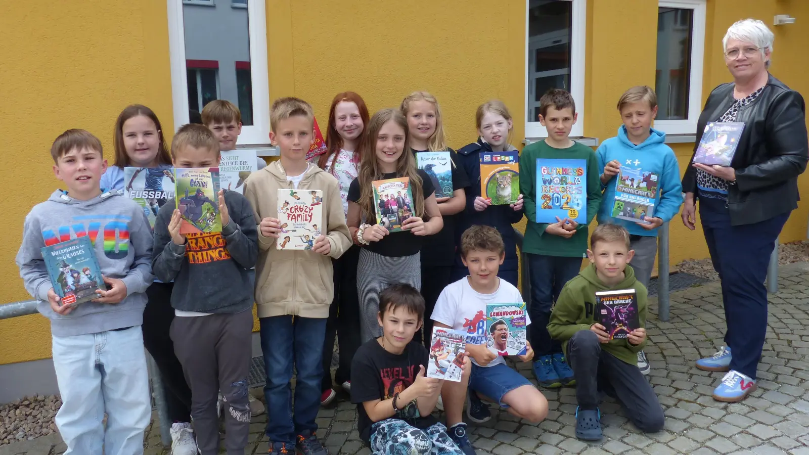 Mit ihrer Lehrerin Simone Friedl präsentierten die Kinder stolz die Bücher, die selbst ausgesucht hatten. (Bild: Sieglinde Schärtl )