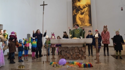 Um den Altar versammelt beteten gemeinsam die maskierten Kinder mit Pfarrer Klösel, der Erzieherin Gaby Hagn sowie die Eltern mit ihren Kleinkindern das „Vaterunser”. (Bild: Peter Garreiss)
