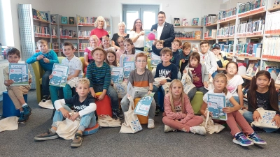 Bürgermeister Thomas Falter (hinten v. rechts) und Büchereileiterin Christina Kostka überreichten Urkunden und Preise an die Teilnehmerinnen und Teilnehmer des diesjährigen Sommerferien-Leseclubs.  (Bild: Michael Weiß)