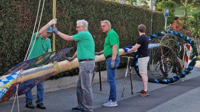 Noch liegt der geschmückte Baum mit Schildern der Innungs- und Berufszünfte, die neu angeschafft wurden, auf Holzböcken. (Bild: R. Kreuzer)