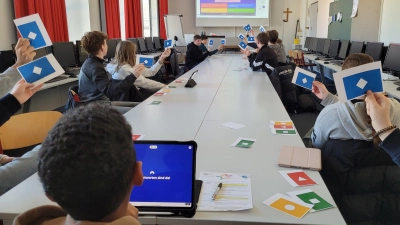 Mit den Symbolkarten treffen die Achtklässler in Sekundenschnelle eine Entscheidung, welche der vorgegebenen Antworten aus dem Livestream richtig sind. Mit diesem Teamwork kommen sie aufs Podium beim European-Money-Quiz. (Bild: Markus Wagner)