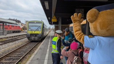 Bei der Einfahrt des Agilis Zuges winken die Kindergartenkinder und „Toni der Bär” dem Agilis-Zugführer Andreas Casper zu. Natürlich hinter der weiße Linie (Bild: Johann Miesbeck)
