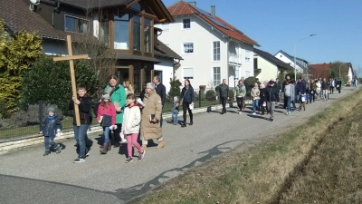 Die Kinder tragen im sogenannten Pfennigweg das Kreuz voraus, zahlreiche Familien folgen dem Kreuz bei schönstem Märzwetter. (Bild: Michael Götz)