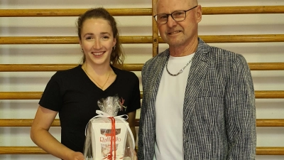 Vorsitzender Wolfgang Rahm übergab ein kleines Geschenk als Anerkennung an Alina Hinrichsmeyer. (Bild: Turngemeinschaft Tirschenreuth/exb)