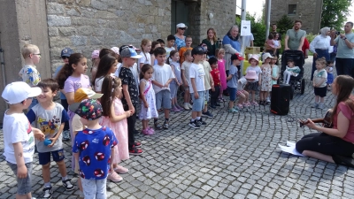 Die Kinder des Kindergartens Herz Jesu eröffneten mit einem Lied die „Bunte Wiese“, rechts Leiterin Fabienne Heining (Bild: Alfons Prechtl)