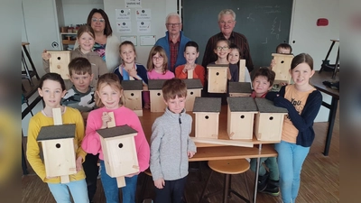 Stolz zeigen die Ferienkids ihre Nistkästen, die sie unter Anleitung von Karl Bock und Josef Eckl vom OWV Moosbach gebaut haben (Bild: Birgit Gerlach-Kneißl)