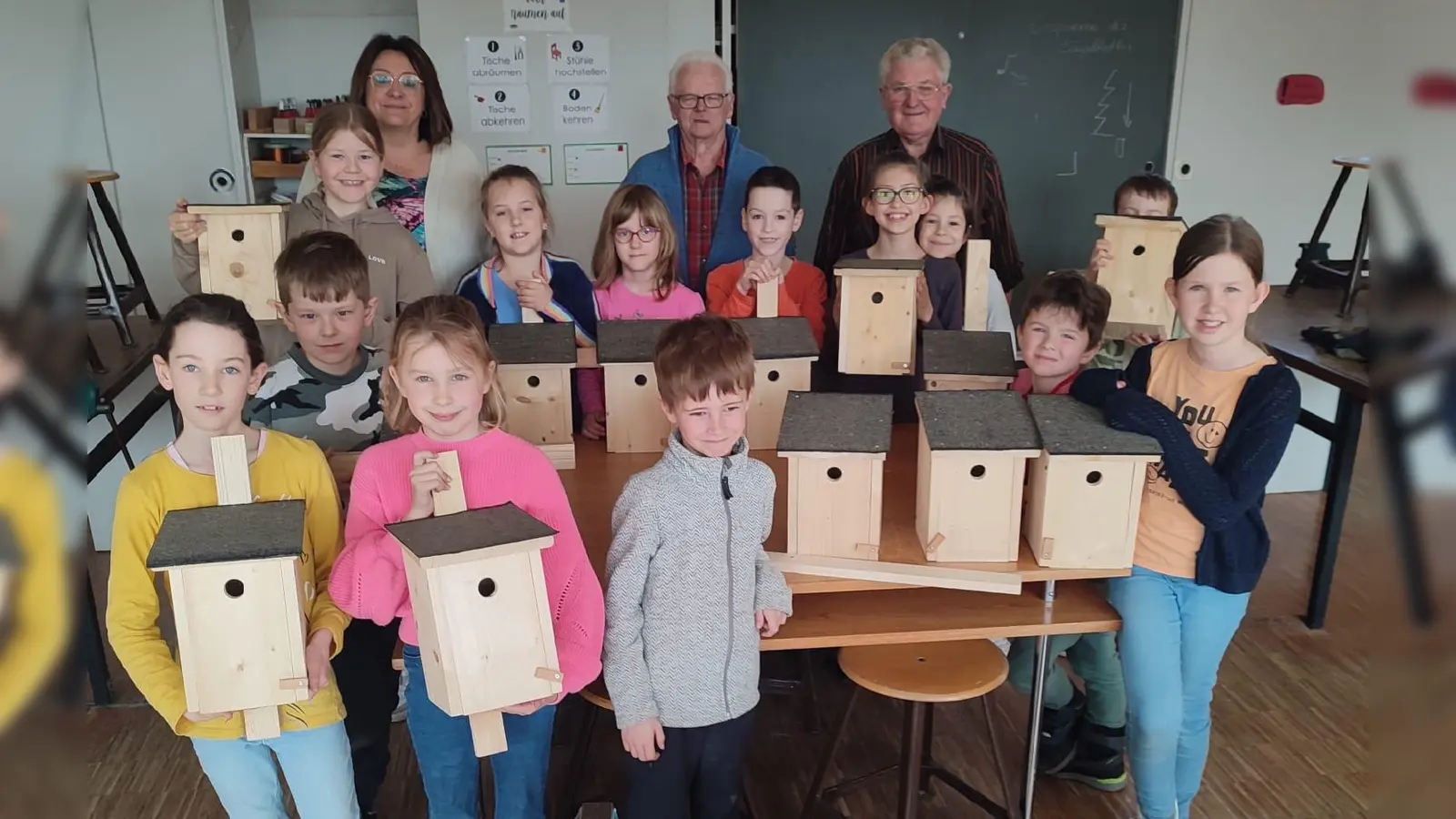 Stolz zeigen die Ferienkids ihre Nistkästen, die sie unter Anleitung von Karl Bock und Josef Eckl vom OWV Moosbach gebaut haben (Bild: Birgit Gerlach-Kneißl)