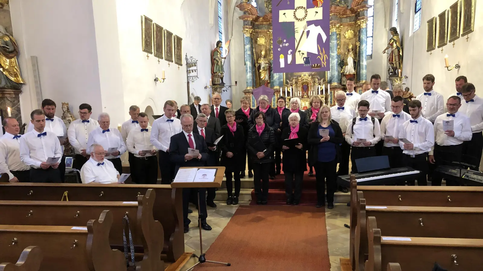 Mit einem gemeinsam gesungenen Lied beschlossen die Chöre - Kirchenchor Schlicht (Mitte) und MGV Schlicht sowie Organisator Heinz Krob (am Pult)- das eindrucksvolle Passionssingen in der Pfarrkirche in Schlicht.  (Bild: Christian Trummer)