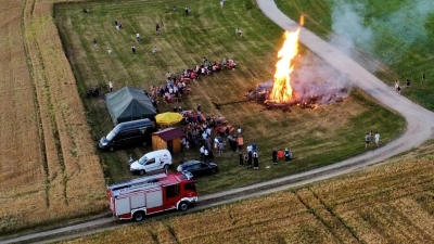 Aus der Vogelperspektive: Zahlreiche Besucher verfolgten gespannt, wie beim Johannisfeuer der Kolpingsfamilie Friedenfels hohe Flammen in den klaren Abendhimmel loderten. (Bild: Christian Schraml)
