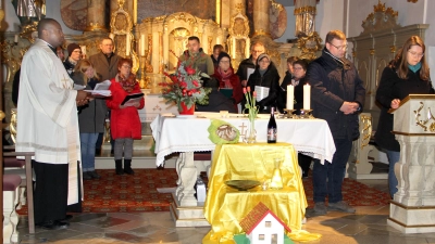 Schon seit mehreren Jahren gestaltet das Ehepaar Michaela und Thomas Müller (am Ambo) mit stets neuen Ideen die Feier zum Valentinstag in der Pfarrkirche. Im Bild links Pfarrvikar Kenneth Onuoha, im Hintergrund die Chorgemeinschaft „Venite“. Ehepaare brachten die Gegenstände im Vordergrund an den Altar, die als symbolhafte Zeichen für das alltägliche Miteinander stehen.  (Bild: Josef Böhm)