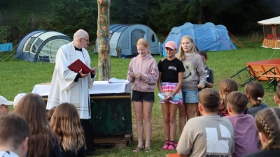 Vor dem von den Teilnehmern gestalteten Lagerkreuz und Altar wurde mit Pfarrer Berzl gemeinsam der Gottesdienst gefeiert. (Bild: Thomas Held)