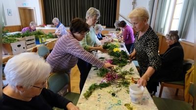 Bis zu 20 Frauen machten sich am Freitag im Pfarrsaal St. Josef an die Arbeit und banden mehr als 250 Stück Palmbuschen, die vor und während der Gottesdienste am Samstag und Sonntag reichen Absatz fanden. Der Erlös kommt ausschließlich Schwester Ellen in Südafrika für die an Aids erkrankten Kinder zugute. (Bild: Fred Lehner)