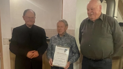 An Adolf Legath (Mitte) übergaben Pfarrer Heribert Stretz und Vorsitzender Reinhold Meyer (von links) die Ernennungsurkunde zum Ehrenvorsitzenden des Kapellenbauvereins. (Bild: Herbert Tretter/exb)