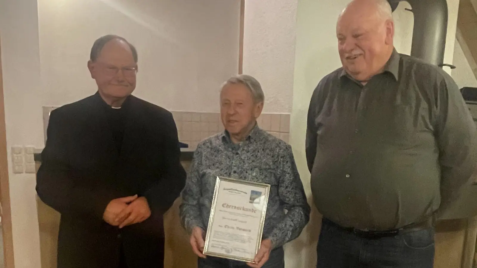 An Adolf Legath (Mitte) übergaben Pfarrer Heribert Stretz und Vorsitzender Reinhold Meyer (von links) die Ernennungsurkunde zum Ehrenvorsitzenden des Kapellenbauvereins. (Bild: Herbert Tretter/exb)