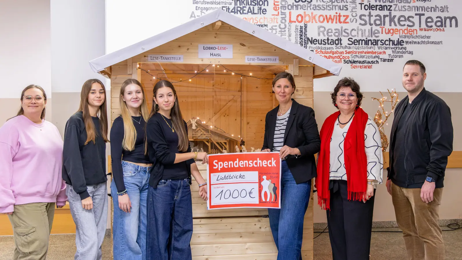 Die Schülersprecherinnen Luisa Kraus, Samira Porsch und Lena Hofmann (von links) überreichten zusammen mit den Verbindungslehrern Sarah Kufner (links) und Bastian Lobinger (rechts) sowie Schulleiterin Irene Sebald (Zweite von rechts) „Lichtblicke“-Vorsitzender Viola Vogelsang-Reichl einen Scheck über 1000 Euro aus dem Erlös des Weihnachtsaktionstags.  (Bild: Luisa Oppel)