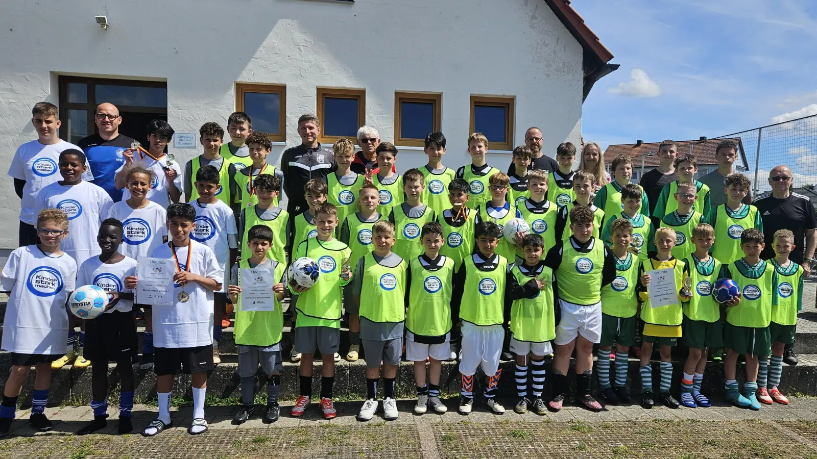 Die vier Jungen-Mannschaften nach der Landkreismeisterschaft der 5. und 6. Klassen auf dem Sportgelände des FV Vilseck (von links): 1. MS Vilseck I, 2. MS Kümmersbruck I, 3. MS Kümmersbruck II und 4. MS Vilseck II mit (hinten, von links) Martin Winkler, Rektor Florian Fuchs (Kümmersbruck), Schiedsrichter Christian Trummer, Lehrer Matthias Brüchner (Kümmersbruck), Konrektorin Claudia Neidl (Vilseck), Bastian Graf und Kevin Sanchez (beide Betreuer Vilseck II) sowie 2. Reihe rechts Karl Heinz Grollmisch. (Bild: Karl Heinz Grollmisch)
