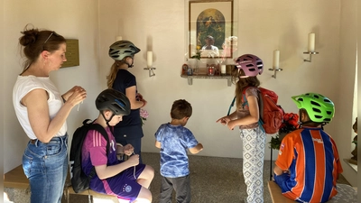 An der Kapelle „Maria Knotenlöserin” startete die Radl-Maiandacht und die pastorale Mitarbeiterin Julia Plödt (links) betrachtete mit den Kindern das Marienbild. (Bild: Diana Argauer)