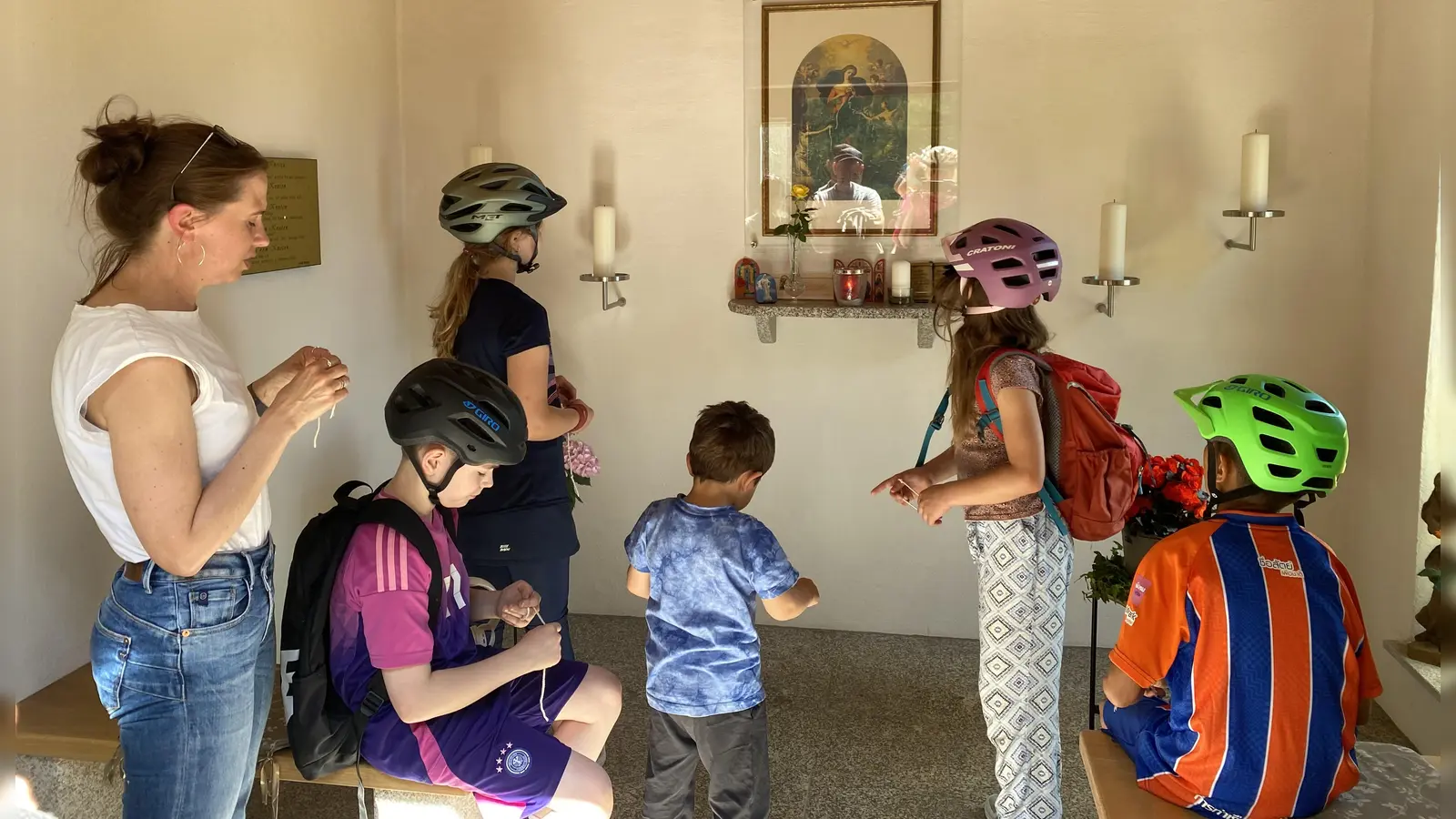 An der Kapelle „Maria Knotenlöserin” startete die Radl-Maiandacht und die pastorale Mitarbeiterin Julia Plödt (links) betrachtete mit den Kindern das Marienbild. (Bild: Diana Argauer)